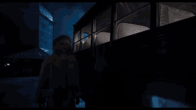 a person is standing next to a bus with a flashlight .