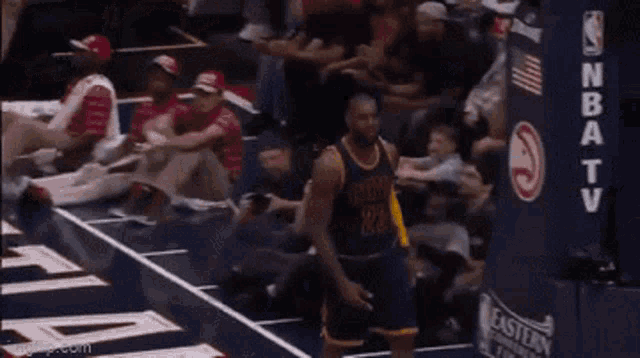 a basketball player with the number 23 on his jersey walks on the court