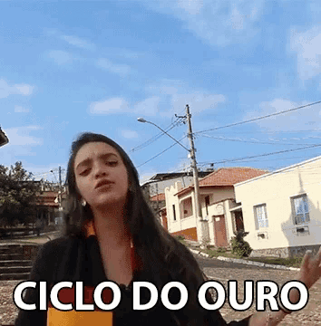 a woman is standing in front of a street with the words ciclo do ouro on the bottom