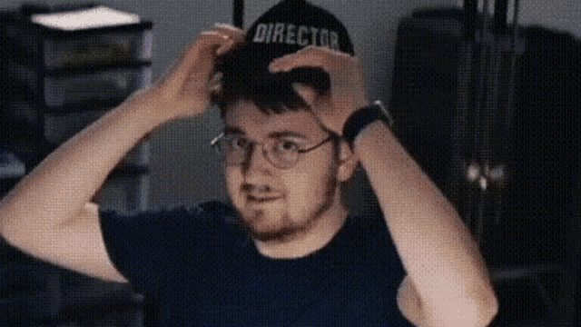 a man wearing glasses and a black hat that says director on it