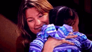 a woman is holding a baby in her arms while smiling