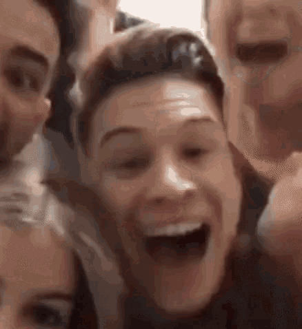 a group of people are taking a selfie together and one of them is smiling .