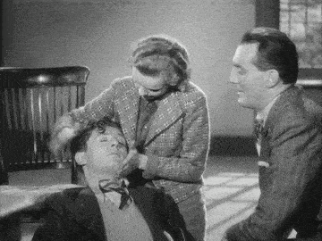 a man in a bow tie is being examined by a woman in a plaid suit