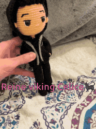 a person holding a crocheted doll with the name reine viking celice written on the bottom