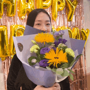 a woman covering her face with a bouquet of flowers