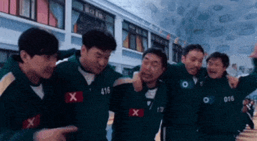 a group of men are standing next to each other in a room in a gym .