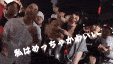 a group of people are dancing in a crowd with chinese writing on the bottom