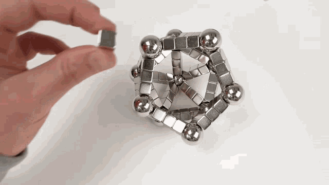 a person is holding a cube made of magnets