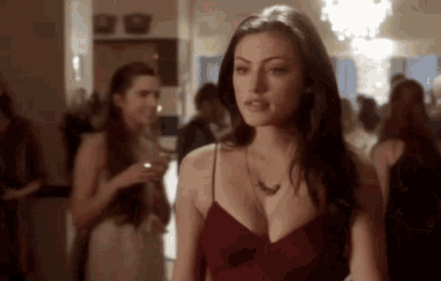 a woman in a red dress stands in a crowd