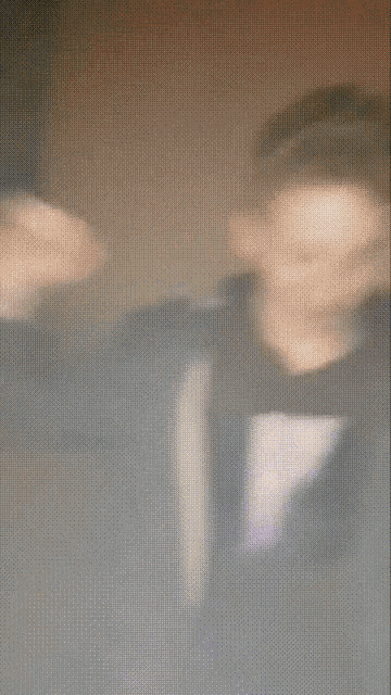 a blurry picture of a man wearing a sweatshirt that says ' a ' on it