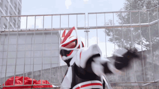 a person in a superhero costume is standing in front of a fence