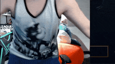 a man in a league of legends shirt is playing a game