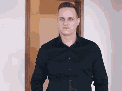 a man in a black shirt stands in a doorway