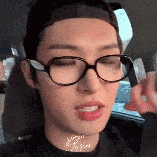 a close up of a person wearing glasses and a black shirt