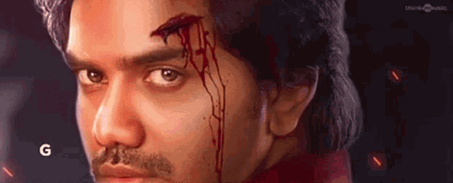 a close up of a man 's face with blood running down his face .