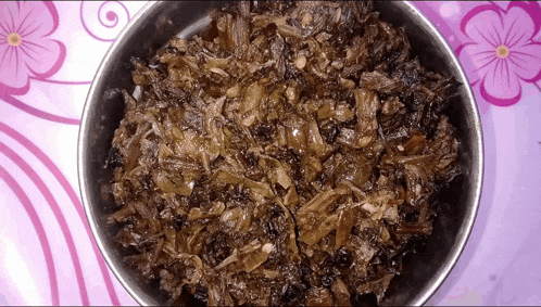 a bowl of food is on a table with purple flowers