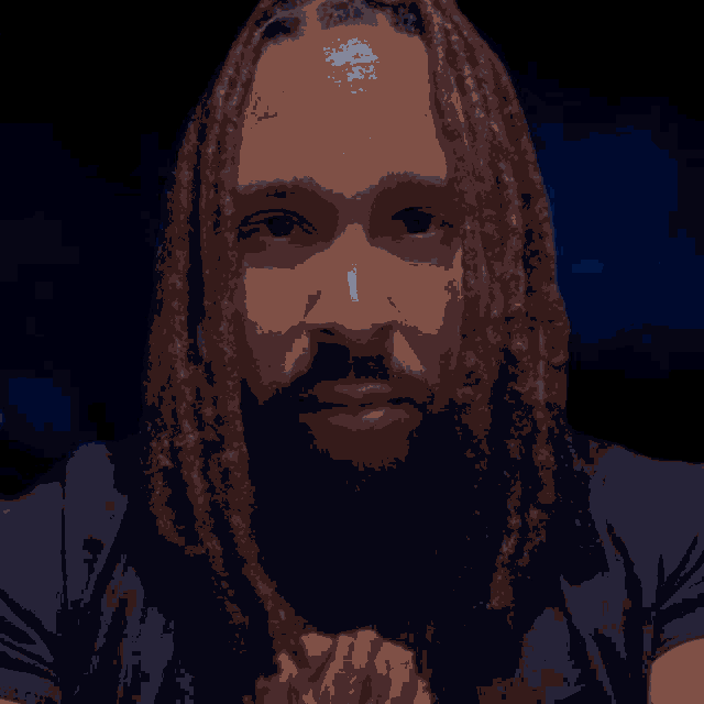 a man with dreadlocks and a beard is wearing a black shirt