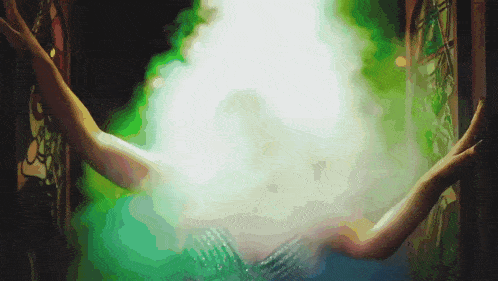 a person 's hands are reaching out towards a bright light