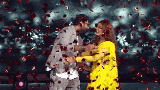 a man and a woman are dancing with confetti falling on them