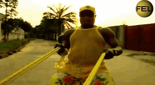 a man in a yellow tank top is pulling a yellow rope with the word fel on the bottom