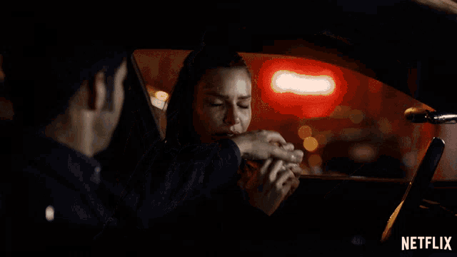 a man and a woman in a car with a netflix logo