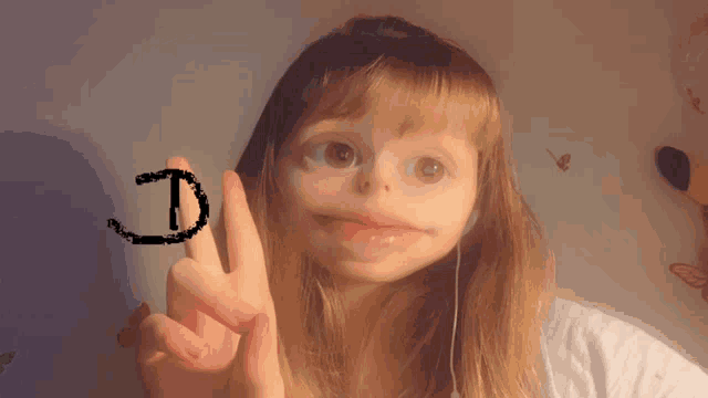 a girl is making a face with her finger and the letter d is drawn on her finger