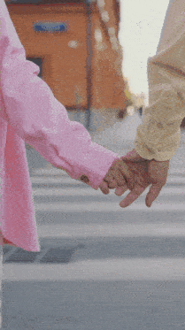 a couple holding hands in front of a window that says love