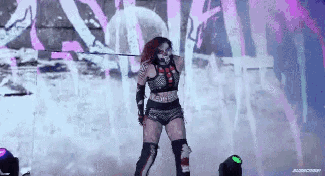 a woman in a clown costume is holding a sword in her hand .