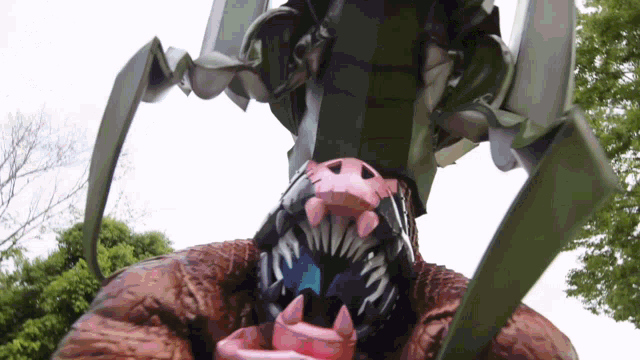 a statue of a monster with sharp teeth and a pink nose