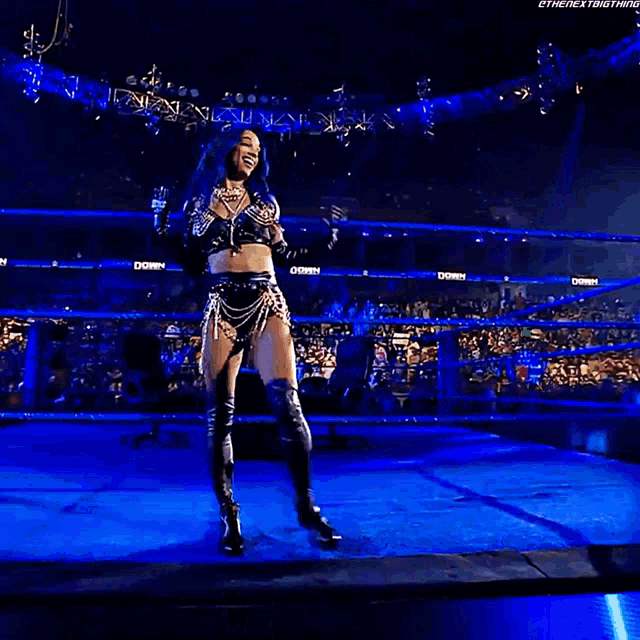 a woman is standing in a wrestling ring holding a firework display