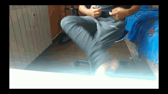 a man sitting on a chair with his legs crossed and his pants saying columbia on them