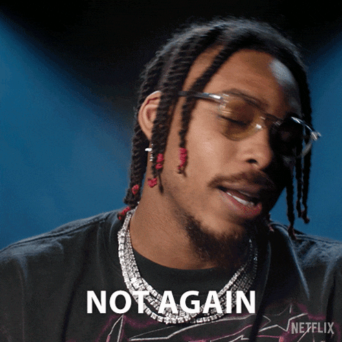 a man with dreadlocks is wearing sunglasses and a black shirt that says not again on it