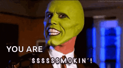 a man in a suit and tie with a green mask on his face is saying you are smokin ' .