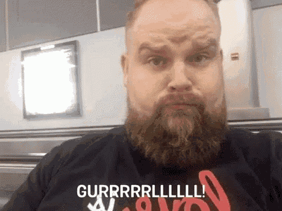 a man with a beard is wearing a shirt that says gurrrrl