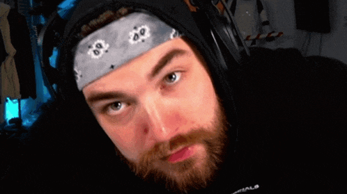 a man with a beard wearing headphones and a bandana with the number 80 on it