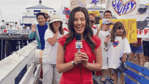 a woman in a red dress is holding a microphone in front of a crowd with a sign that says smurfs on it