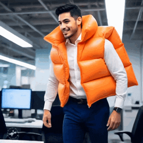 a man wearing a large orange vest is walking in an office