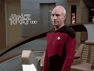 a man in a star trek uniform is standing in a room with chinese writing on the wall behind him