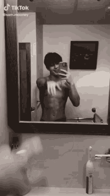 a shirtless man taking a picture of himself in a bathroom mirror with a tiktok watermark