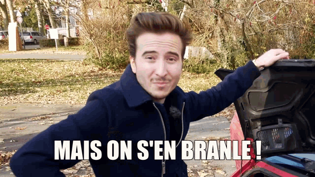 a man standing next to a car with the words mais on s'en branle written on the bottom