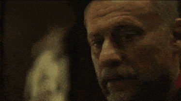 a man in a suit and tie is standing in front of a painting and says we call him baba yaga
