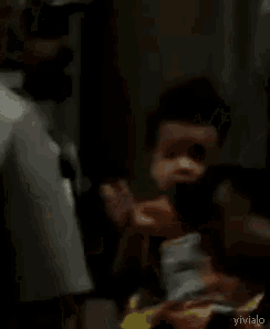a blurred image of a person holding a baby with the word vivialo on the bottom right