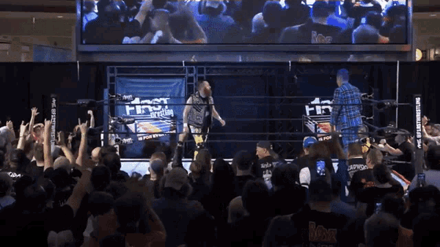 a man in a wrestling ring with a sign behind him that says first class wrestling