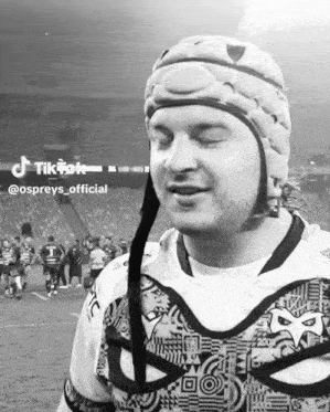 a black and white photo of a man wearing a helmet and a shirt that says ospreys official