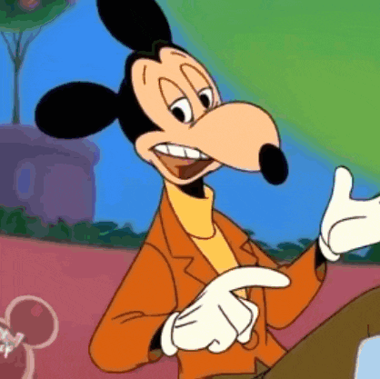 mickey mouse is wearing a suit and gloves and pointing at the camera .