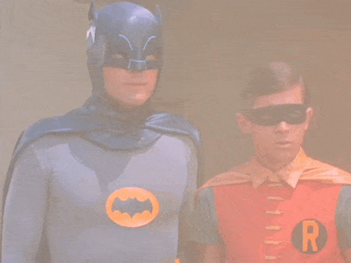 a man in a batman costume stands next to another man in a robin costume