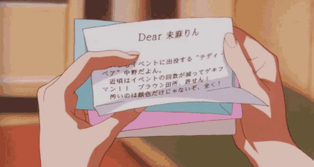a person holding a piece of paper that says dear