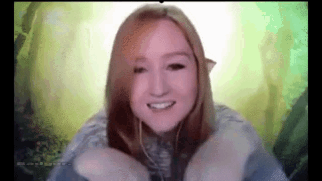 a woman is smiling in front of a green screen with the word badger on it