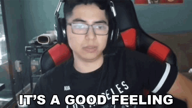 a man wearing glasses and headphones is sitting in a chair and says it 's a good feeling