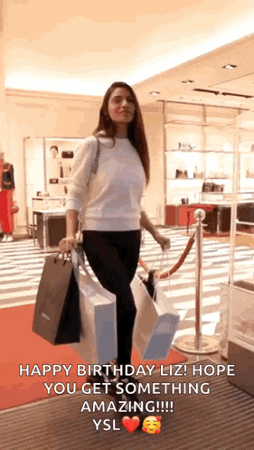 a woman is holding shopping bags in a store and says happy birthday liz ! hope you get something amazing !!!